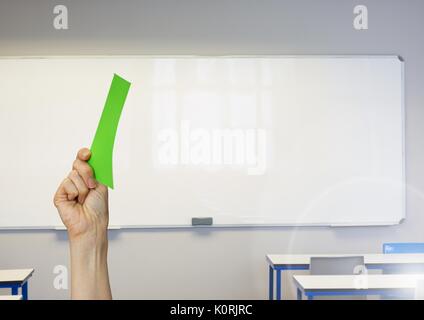 Digital composite einer Hand, die eine grüne Karte vor der Bildfläche Stockfoto