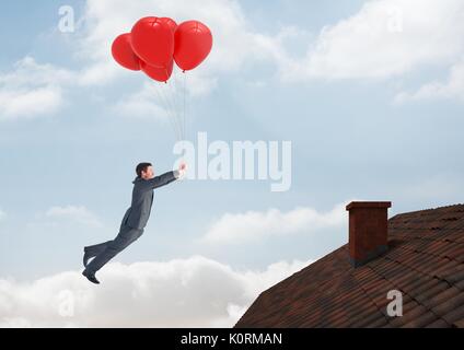 Digital composite der Geschäftsmann floating mit Ballons von Dach mit Kamin und blauer Himmel Stockfoto