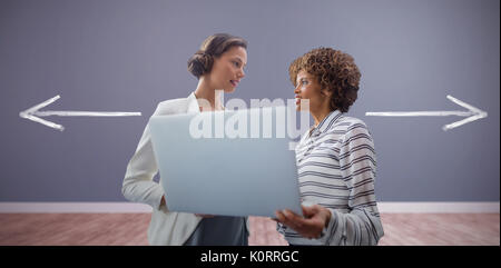 Portrait von Unternehmerinnen mit Laptop gegen Zimmer mit Holzboden posing Stockfoto