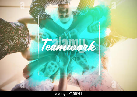 Teamwork Sms gegen direkt unter Portrait von lächelnden Geschäft Leute stapeln Hände Stockfoto