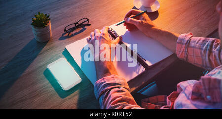 7/8 Hände der Geschäftsmann schreiben in Tagebuch am Schreibtisch Stockfoto