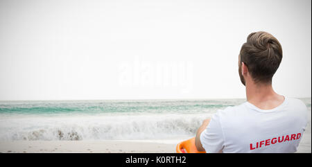 Ansicht der Rückseite des männlichen Rettungsschwimmer sitzen auf Stuhl gegen malerische Aussicht auf Wellen auf dem Meer Stockfoto