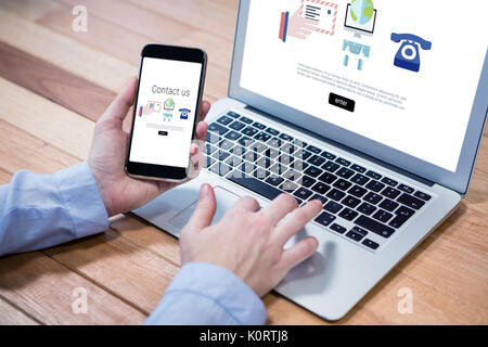 Symbole mit uns Kontakt Text gegen Geschäftsfrau mit Handy und Laptop Stockfoto