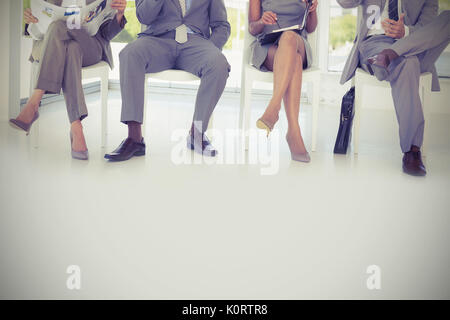 Business-Leute sitzen auf Stühlen im Büro Stockfoto