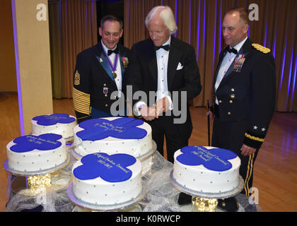 Kommandierender General des 88th World Support Command Generalmajor Patrick Reinert, rechts, und 88th RSC-Befehl Sgt. Maj. Earl Rocca zusammen mit Thema und Geschäftsmann Robert Edsel, Mitte, einen Kuchen schneiden Zeremonie, während ein 88Th RSC-Hauptquartier und die Konzernzentrale Bankett in Warrens, Wis am 12.08.19, zu Ehren des 100-jährigen Bestehens der 88th Division führen. Stockfoto