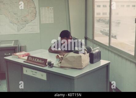 Lieutenant AL Walker, sitzt an seinem Schreibtisch lesen an langen Binh Post, Logistik Center und großen Befehl Hauptquartier für die United States Army Vietnam, Vietnam, 1970. Stockfoto