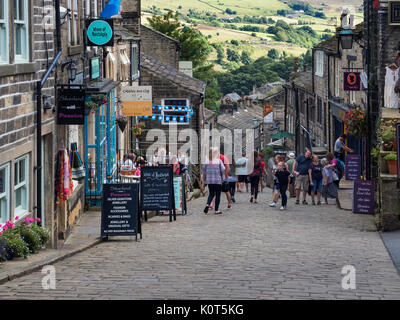 Besucher auf dem Hügel auf der Main Street in Haworth West Yorkshire England Stockfoto