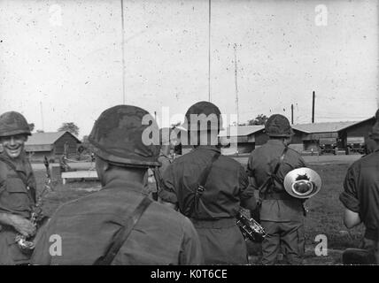 Die Mitglieder des 1.Infanterie Division Band mit ihren Instrumenten, ein Mitglied gegenüber der Fotograf eingeschaltet ist und lächelnd, Vietnam, 1967. Stockfoto