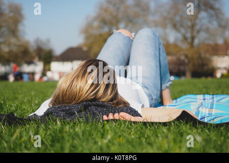 Junge Frau entspannen in Südost London Park. April, 2017. Querformat. Stockfoto