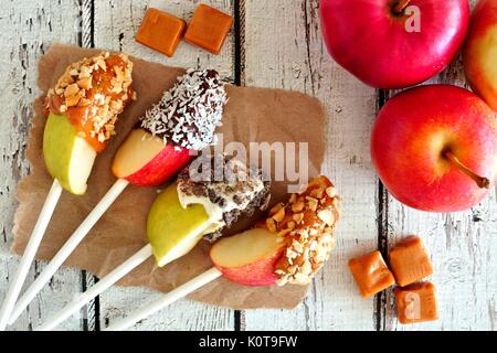 Herbst äpfel Schichten Abblendlicht mit Schokolade und Karamell, Szene auf einem rustikalen weißem Holz Stockfoto