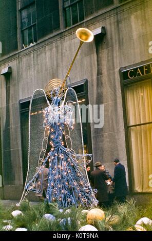 Blick auf einen Draht Skulptur Weihnachten Engel Dekoration im Kanal Gärten Promenade von Rockefeller Center Plaza entfernt, Midtown Manhattan, New York City, Dezember, 1955. Diese Trompeten Angel von Künstlerin Valerie Clarebout ist eine frühe Version der Engel Skulpturen später auf permanente Anzeige in 1969 platziert. Stockfoto