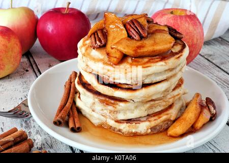 Herbst Pfannkuchen mit Bratapfel, Pekannüsse und Zimt gekrönt mit Ahornsirup, Tisch Szene Stapel Stockfoto