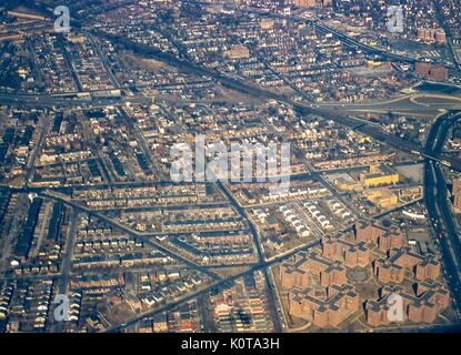 Luftaufnahme nördlich der Nachbarschaften von Middle Village, Rego Park und Elmhurst, Queens, New York City, 1957. Die Bahngleise der Long Island Rail Road (LIRR) nach Forest Hills verlaufen schräg von der oberen linken Ecke nach rechts in der Mitte und überqueren den Long Island Expressway (LIE) und den Woodhaven Boulevard. Die KLEEBLATT-Kreuzung LIE's Exit 19 befindet sich am rechten Rand der Mitte. Horace Harding Hospital (später St John's Hospital), 90-02 Queens Boulevard und Hoffman Park liegen zwischen den beiden. Gegenüber vom Krankenhaus am 90-05 Queens Blvd ist das Fairyland Park Amusement Center an der Kreuzung Stockfoto