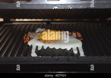 Speck auf einem Grill mit Ei Stockfoto