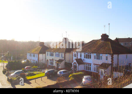 Verschwommen und hellen Englisch reichen modernes Haus mit hellen blauen Himmel und Garten Baum. Traditionelle britische Dorfstraße mit Wohnsitz Brick House auf s Stockfoto