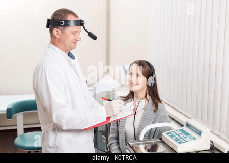 Arzt otolaryngologist des Patienten geprüft. Diagnose der Anhörung eine spezielle Apparatur mit Kopfhörern. Stockfoto