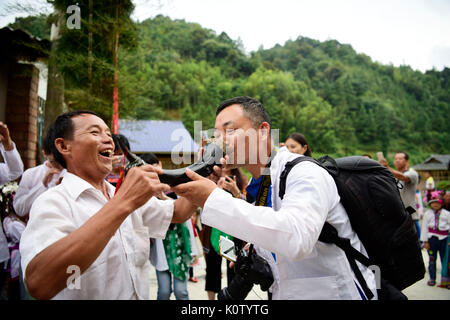 Qiangdongnan, China. 23 Aug, 2017. Ein Dorfbewohner schlägt einen Toast zu Gast in Yangli Dorf Dong ethnische Gruppe in Congjiang County, im Südwesten Chinas Provinz Guizhou, 23.08.2017, einen Tag vor dem jährlichen "Xinmi" Festival. Die Menschen vor Ort durchgeführt, Trommel, Gesang und lusheng, ein Reed-pipe Blasinstrument, zu feiern Das traditionelle Fest für die Ernte zu beten. Quelle: Xinhua/Alamy leben Nachrichten Stockfoto