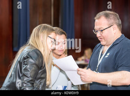 24. August 2017 zwei weibliche Studenten ihre Erben GCSE Ergebnisse im Brentwood County High, Brentwood, Essex, mit Stephen Drew, Schulleiter und TV-Berühmtheit teilen Stockfoto