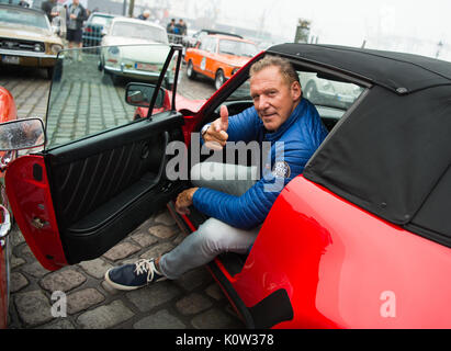 Hamburg, Deutschland. 24 Aug, 2017. Deutsche Schauspieler Ralf Moeller sitzt in einem Porsche 911 Turbo Cabriolet, Baujahr 1989, am Beginn der Oldtimer Rallye Hamburg-Berlin in Hamburg, Deutschland, 24. August 2017. Über 180 Oldtimer begann die Rallye heute. Foto: Christophe Kirschtorte/dpa/Alamy leben Nachrichten Stockfoto