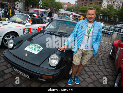 Hamburg, Deutschland. 24 Aug, 2017. Schauspieler Richy Müller steht neben Porsche 911 Turbo, erbaut 1989, zu Beginn der Oldtimer Rallye Hamburg-Berlin in Hamburg, Deutschland, 24. August 2017. Über 180 Oldtimer begann die Rallye heute. Foto: Christophe Kirschtorte/dpa/Alamy leben Nachrichten Stockfoto