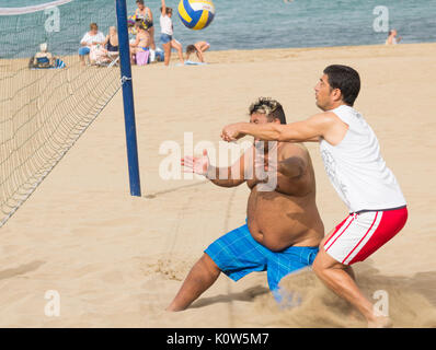 Übergewichtige Menschen spielen Volleyball am Strand in Spanien Stockfoto