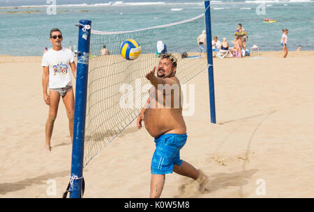 Übergewichtige Menschen spielen Volleyball am Strand in Spanien Stockfoto