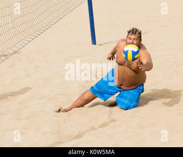 Übergewichtige Menschen spielen Volleyball am Strand in Spanien Stockfoto