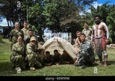 CAIRNS, Australien - U.S. Marines und Soldaten, zusammen mit Soldaten aus der Australian Defence Force und die chinesische Volksbefreiungsarmee posieren für ein Foto nach ihrer Hütte Gebäude während der indigenen australischen Kultur Klassen für Übung Kowari 2017 23.08.2017. Die Soldaten und Marines nahm auch an einige traditionelle Aktivitäten wie Boomerang werfen und tribal Face painting die Besucher aus den USA und China, die mit indigenen australischen Kultur vorzustellen. Kowari ist eine jährliche Fortbildung in Australien statt zu trilateralen militärische Beziehungen, Vertrauen und Co-Betrieb verstärken Stockfoto