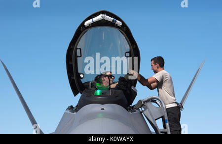 Us Air Force Airman Steven Quinn 27 Aircraft Maintenance Unit, Crew Chief unterstützt Kapitän Rampe, 94th Fighter Squadron, F-22 Raptor Pilot nach der Landung auf der Nellis Air Force Base, Nev August 18, 2017. Quinn und Rampe sind mit dem 94th FS eingesetzt Teil in Red Flag 17-4 an der Nellis AFB zu nehmen. (U.S. Air Force Foto: Staff Sgt. Carlin Leslie) Stockfoto