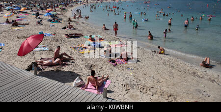 Touristen schwimmen oder genießen Sie maritimen Tätigkeiten, wie sie in den Strand von Magaluf in der spanischen Baleareninsel Mallorca sunbatthe Stockfoto