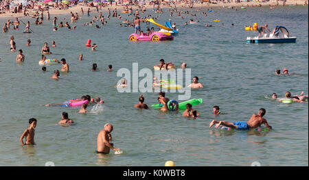 Touristen schwimmen oder genießen Sie maritimen Tätigkeiten, wie sie in den Strand von Magaluf in der spanischen Baleareninsel Mallorca sunbatthe Stockfoto