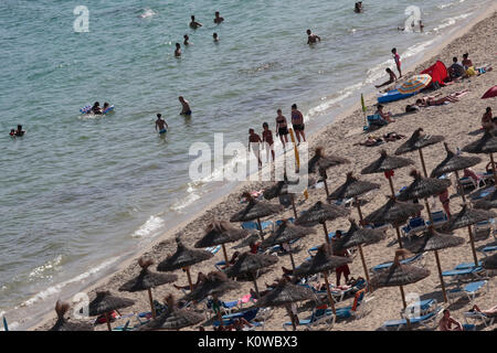 Touristen schwimmen oder genießen Sie maritimen Tätigkeiten, wie sie in den Strand von Magaluf in der spanischen Baleareninsel Mallorca sunbatthe Stockfoto