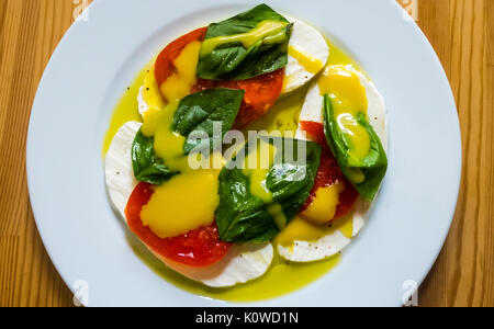 Caprese Salat mit Mozzarella, heirloom Tomaten, Basilikum, mit Honig Senf Dressing in den Farben der italienischen Flagge: rot, grün und weiß Stockfoto