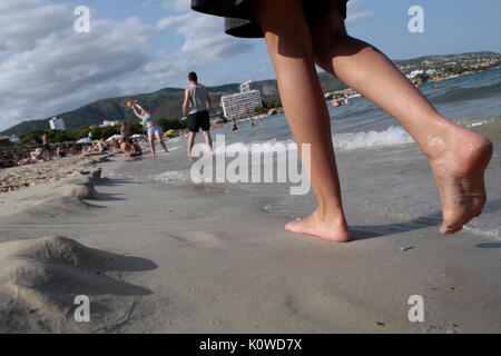 Touristen schwimmen oder genießen Sie maritimen Tätigkeiten, wie sie in den Strand von Magaluf in der spanischen Baleareninsel Mallorca sunbatthe Stockfoto