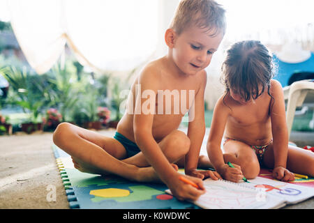 Kleine Jungen und Mädchen zeichnen mit Buntstiften Stockfoto