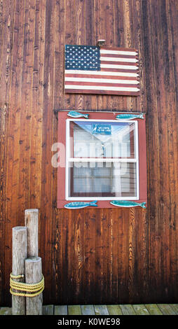 Amerikanische Flagge und Fenster eines Vintage Bootshaus an der Jacksonville City Pier, Arapiraca, Upstate New York, USA, Finger Lakes Boat House pt Stockfoto