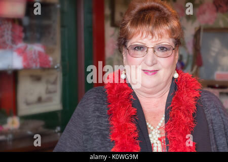 Ketchikan, Alaska, USA - Juli 21th, 2017: Portrait eines Freiwilligen-Hostess der Dolly Haus wer ist draußen vor der Tür des Hauses Besucher t einladen Stockfoto