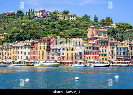 Schönen Tageslicht, um Schiffe auf dem Wasser und Gebäuden in Portofino Stadt Italiens. Touristen zu Fuß auf dem Bürgersteig. Stockfoto