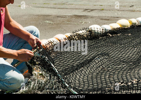 Fischer flickten Fischernetz Stockfoto