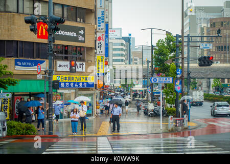 Tokio, Japan, 28. Juni - 2017: Nicht identifizierte Personen unter Sonnenschirmen auf Zebrastreifen Straße in Jimbocho Bezirk in Tokio Stockfoto