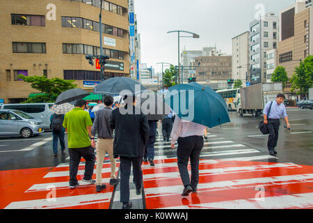 Tokio, Japan, 28. Juni - 2017: Nicht identifizierte Personen unter Sonnenschirmen auf Zebrastreifen Straße in Jimbocho Bezirk in Tokio Stockfoto