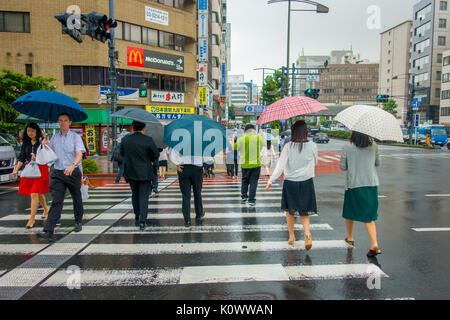 Tokio, Japan, 28. Juni - 2017: Nicht identifizierte Personen unter Sonnenschirmen auf Zebrastreifen Straße in Jimbocho Bezirk in Tokio Stockfoto