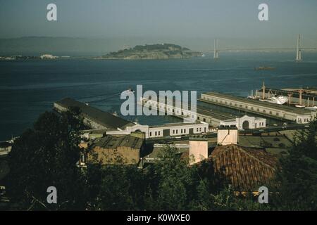 Hyde Street Pier der San Francisco (jetzt Fisherman's Wharf), anzeigen Waterfront Industriebauten mit Docks bis in die Bucht von San Francisco, die Bay Bridge und Yerba Buena Insel im Hintergrund sichtbar, an einem sonnigen Morgen, aus der Presidio Park, 1952 gesehen. Photo credit Smith Collection/Gado/Getty Images. Stockfoto