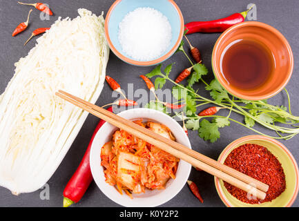 Kimchi - Koreanische superfood. Eingelegte Chinakohl in Schüssel auf schiefer Platte Stockfoto