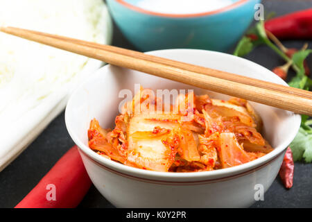 Kimchi - Koreanische superfood. Eingelegte Chinakohl in Schüssel auf schiefer Platte Stockfoto