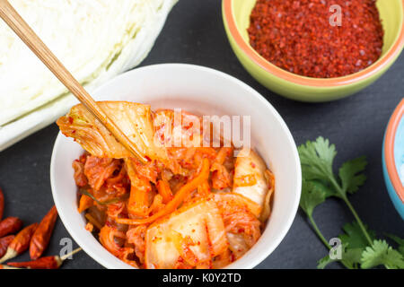 Kimchi - Koreanische superfood. Eingelegte Chinakohl in Schüssel auf schiefer Platte Stockfoto