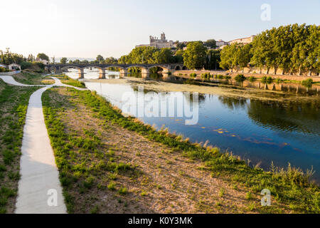 Blick bei Sonnenuntergang der französischen Stadt Beziers, mit Bäumen und eine der Brücken über den Fluss Orb, und aus dem 13. Jahrhundert Kathedrale von Saint wider Stockfoto