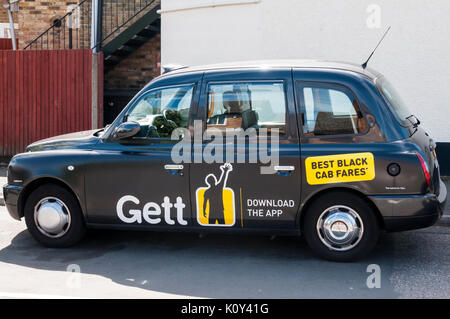 Eine Werbung für die gett App auf der Seite eines schwarzen Londoner Taxi Stockfoto