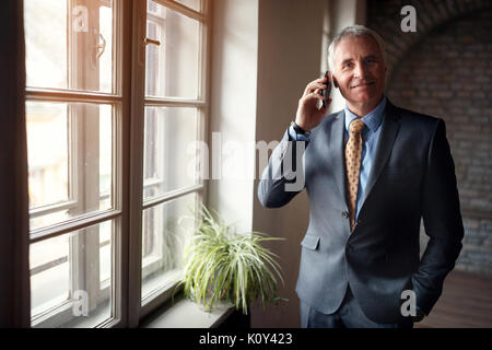 Senior Leader Geschäftsmann in Anzug mit Smartphone Stockfoto
