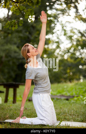 Passende Frau tun, streching Übungen im Park Stockfoto
